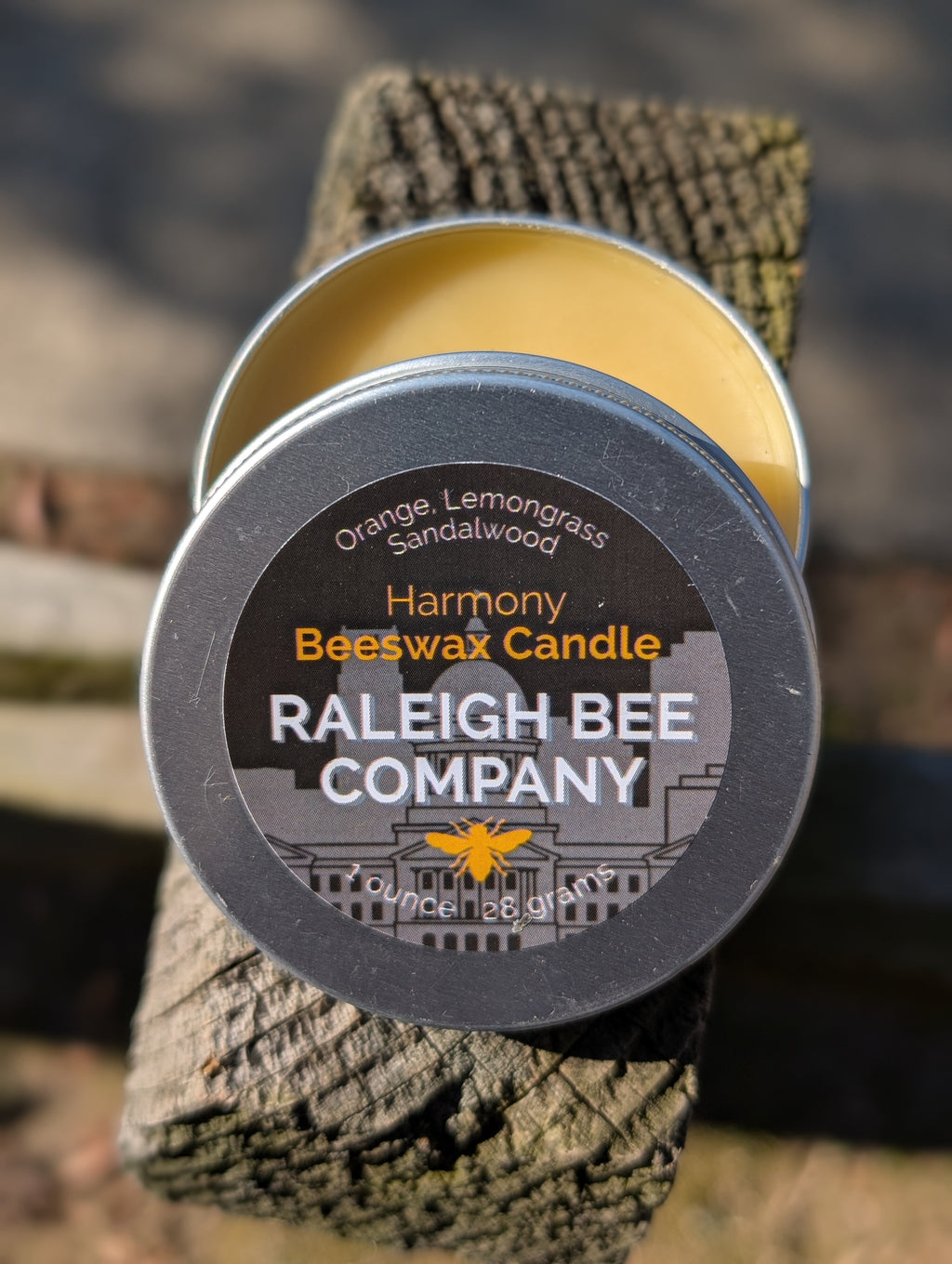 Raleigh Bee Company beeswax candle in a small round tin with 'Harmony' label. Consists of Orange, Lemongrass and Sandalwood.